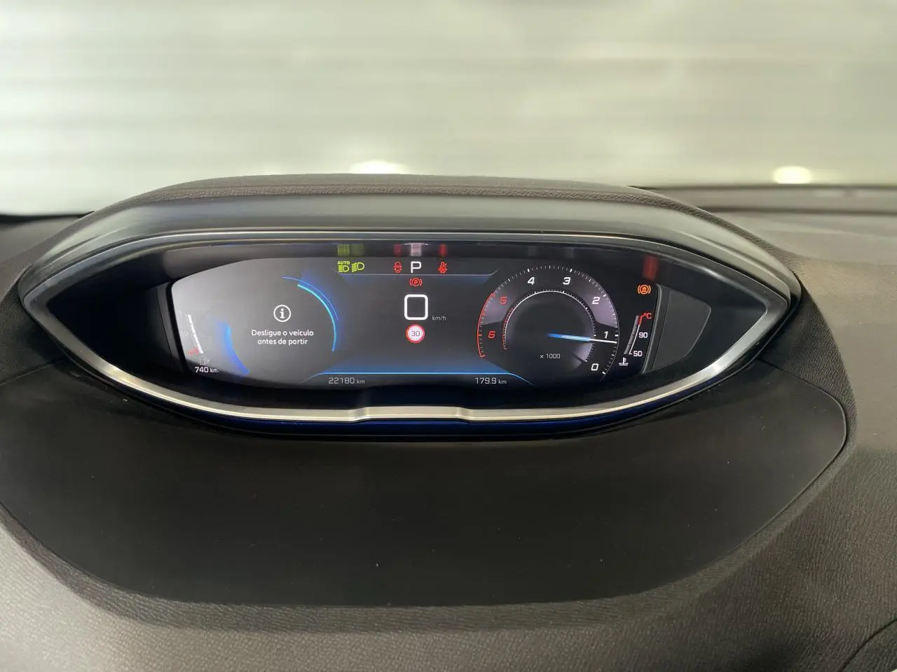 Tableau de bord numérique du Peugeot 5008 2024 affichant vitesse, compte-tours et alertes, vue frontale rapprochée.