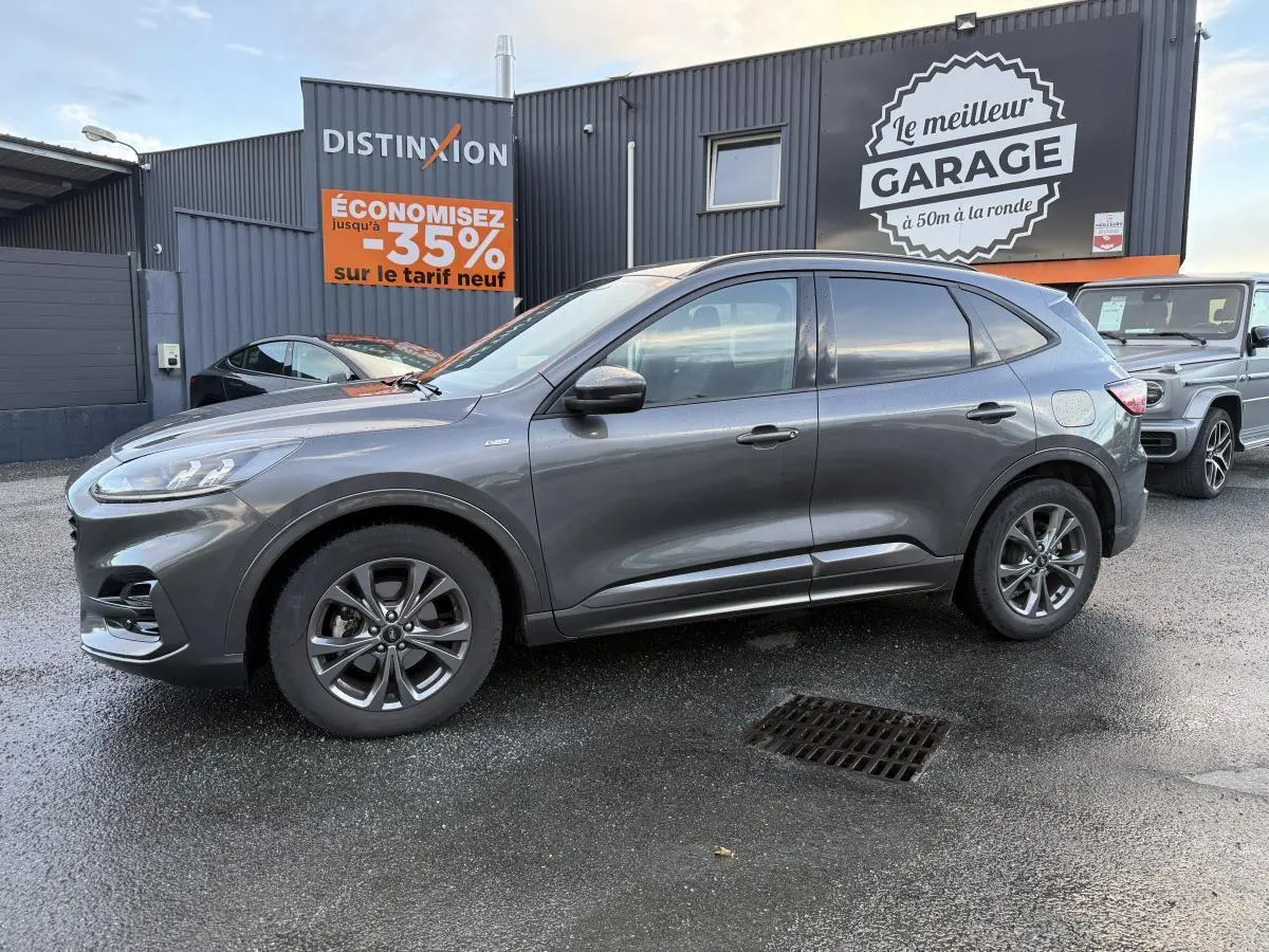 Ford Kuga gris métallisé vu de profil côté gauche, avec jantes alliage 18 pouces et vitres arrière surteintées.