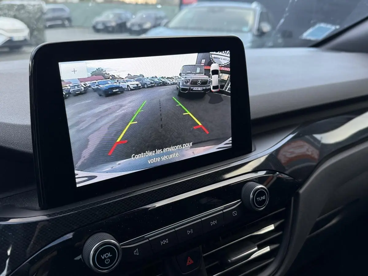 Vue rapprochée de l’écran central affichant la caméra de recul du Ford Kuga gris, avec console noire brillante.
