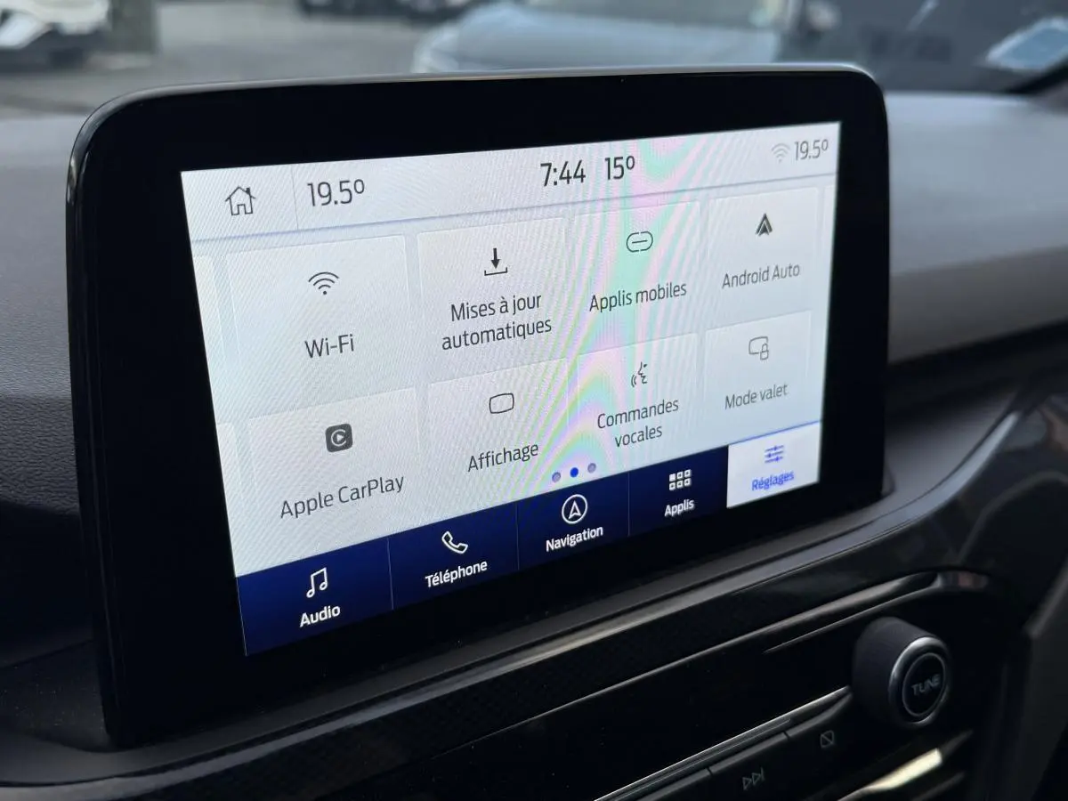 Écran tactile central du Ford Kuga 2022 affichant les réglages connectivité et commandes vocales, intérieur noir.