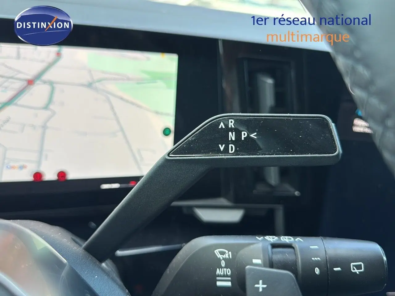 Le levier de vitesses automatique du Renault Austral 2023 en gros plan avec l'écran de navigation en arrière-plan.