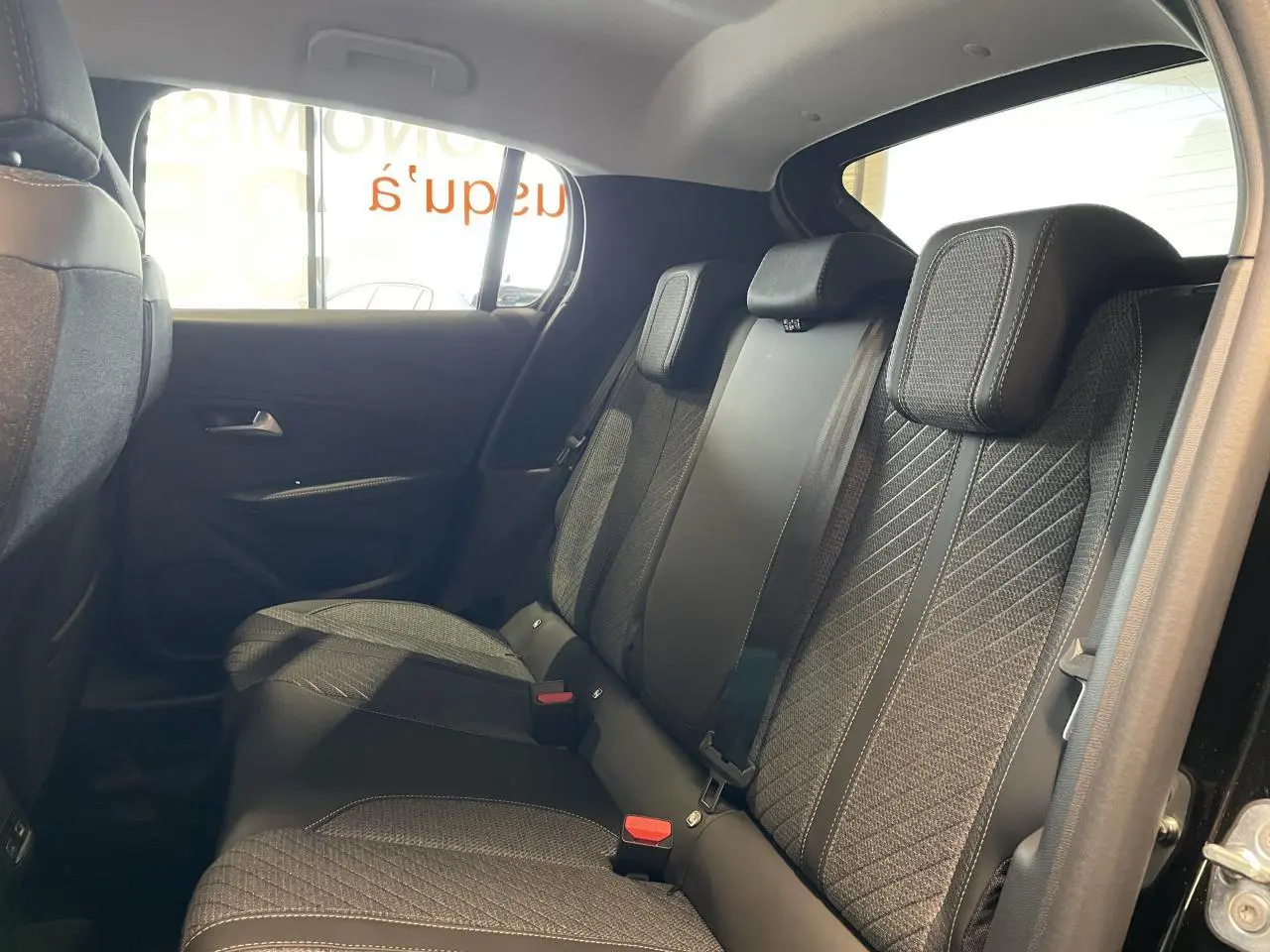 Vue latérale droite de la banquette arrière noire avec surpiqûres Quartz dans une Peugeot 208 1.2i Hybrid 2025.