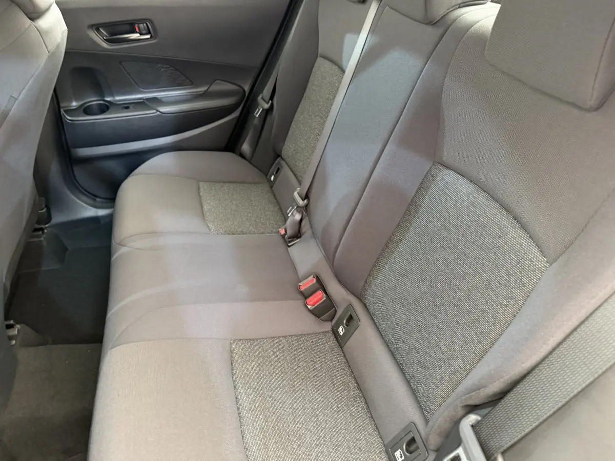 Vue intérieure côté gauche montrant la banquette arrière grise du Toyota C-HR 1.8 Hybride 140 Dynamic 2024.