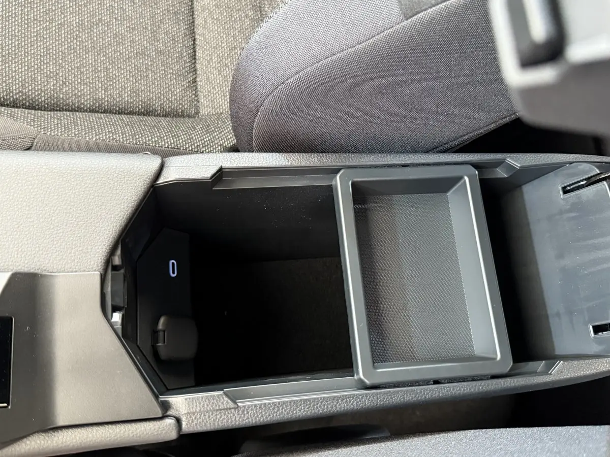 Vue rapprochée de l'accoudoir central ouvert du Toyota C-HR 1.8 Hybride 140 Dynamic avec rangement intérieur noir.