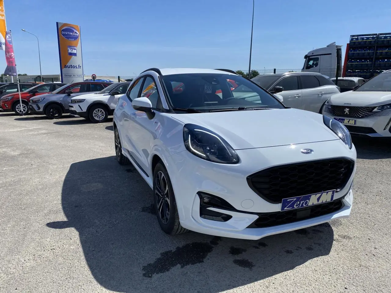 Ford Puma blanc glacier en 3/4 avant droit avec barres de toit noires et jantes alliage 17 pouces.