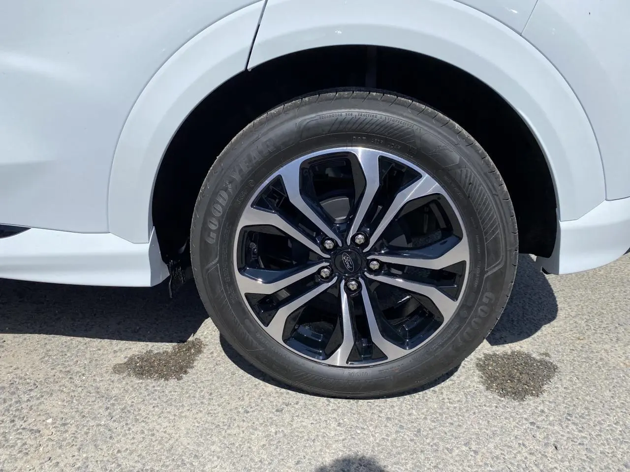 Gros plan sur la roue avant droite du Ford Puma blanc glacier avec jante alliage 17 pouces bicolore.