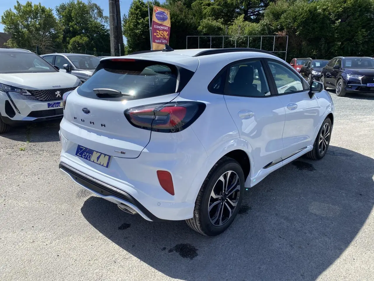Vue 3/4 arrière droite d’un Ford Puma blanc glacier avec barres de toit noires et jantes alliage 17 pouces finition Black Machined.