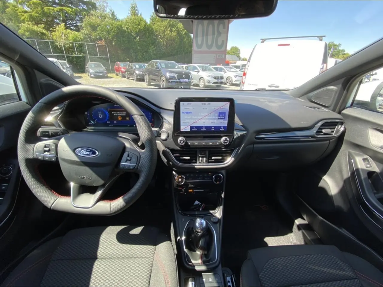 Vue intérieure avant du Ford Puma 2022, tableau de bord moderne avec écran tactile et volant multifonction noir.