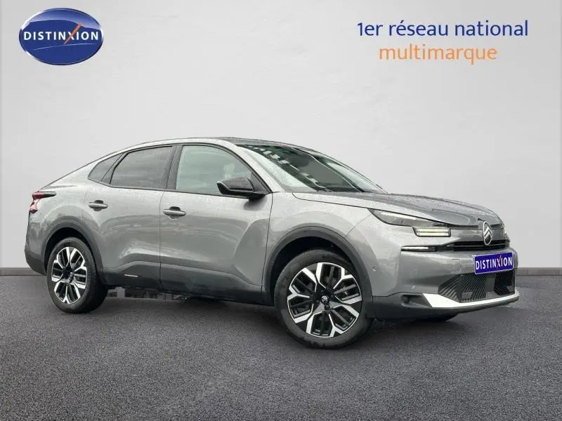 Citroën C4 X 2025 gris Mercury en vue 3/4 avant droit, avec signature lumineuse LED et jantes alliage distinctives.