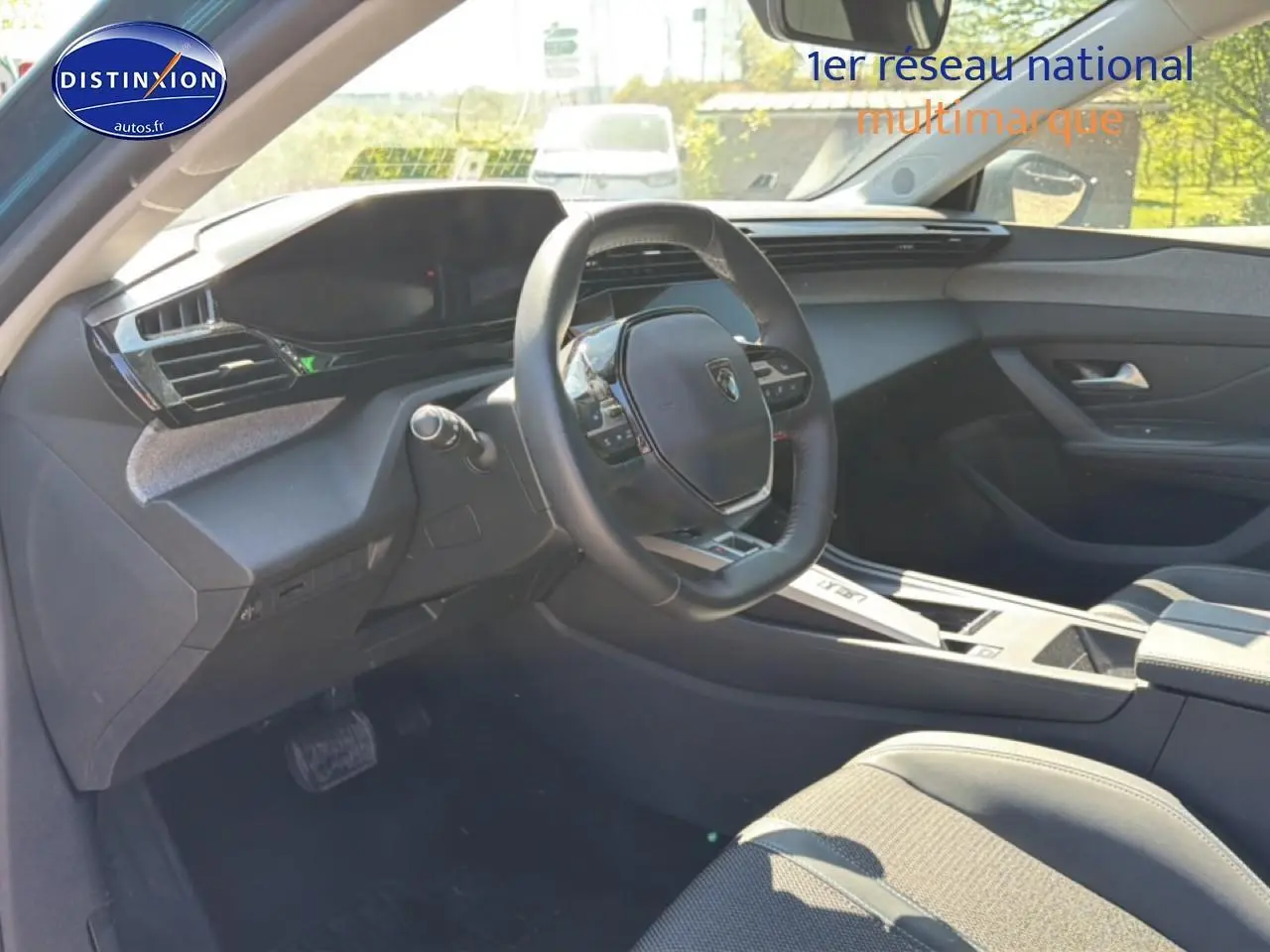 Vue intérieure côté conducteur du Peugeot 408 Hybrid bleu 2025, volant cuir et tableau de bord moderne.