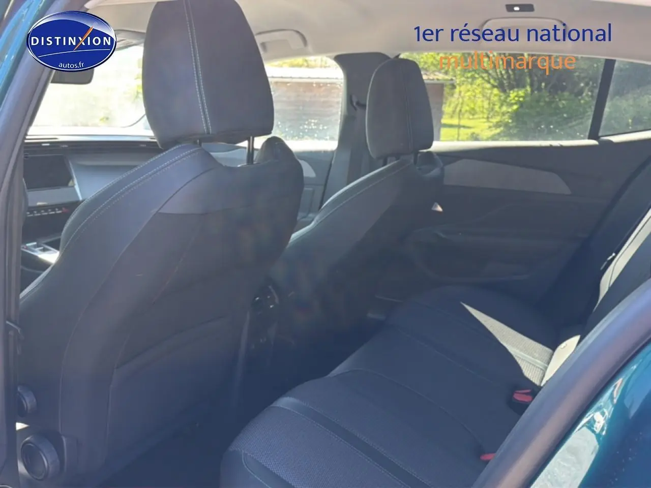 Vue intérieure arrière côté droit du Peugeot 408 Hybrid 145 allure bleu, montrant les sièges et la banquette tissu noire.