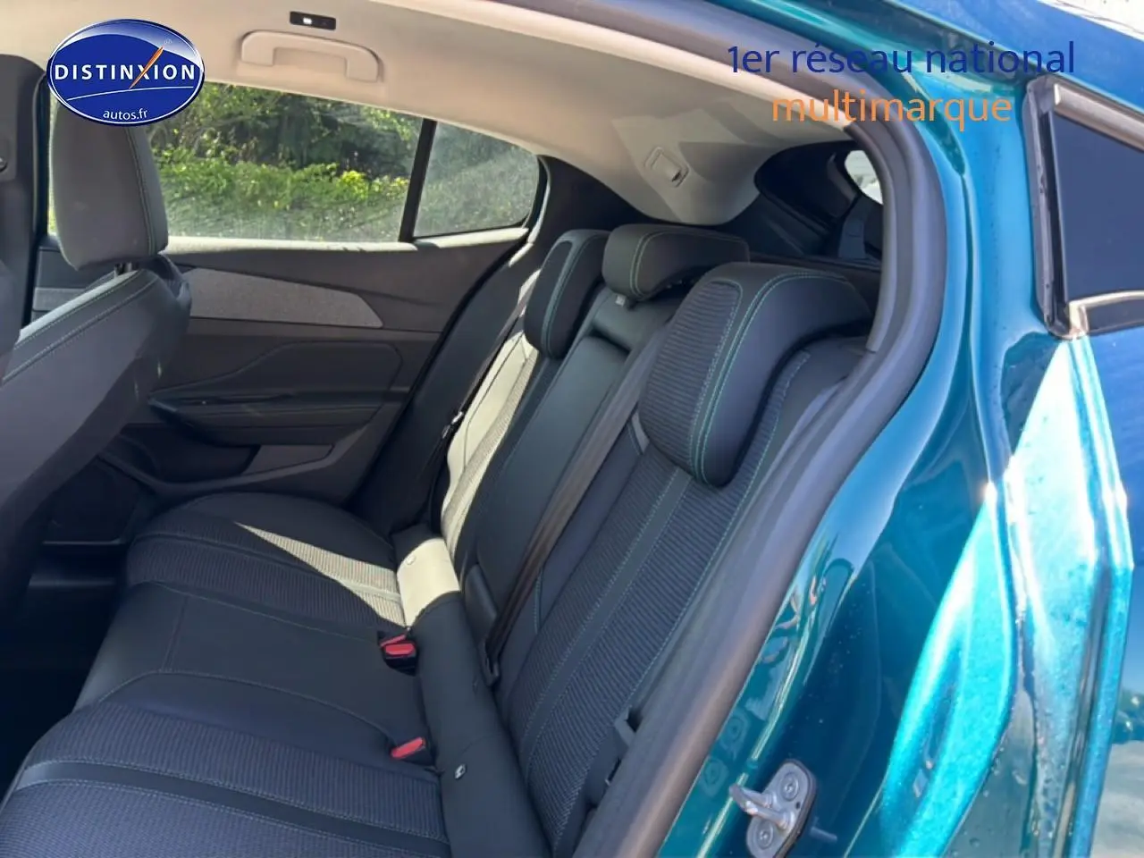 Vue intérieure sur la banquette arrière côté droit d'une Peugeot 408 Hybrid 145 allure bleu 2025, avec sièges tissu et cuir.