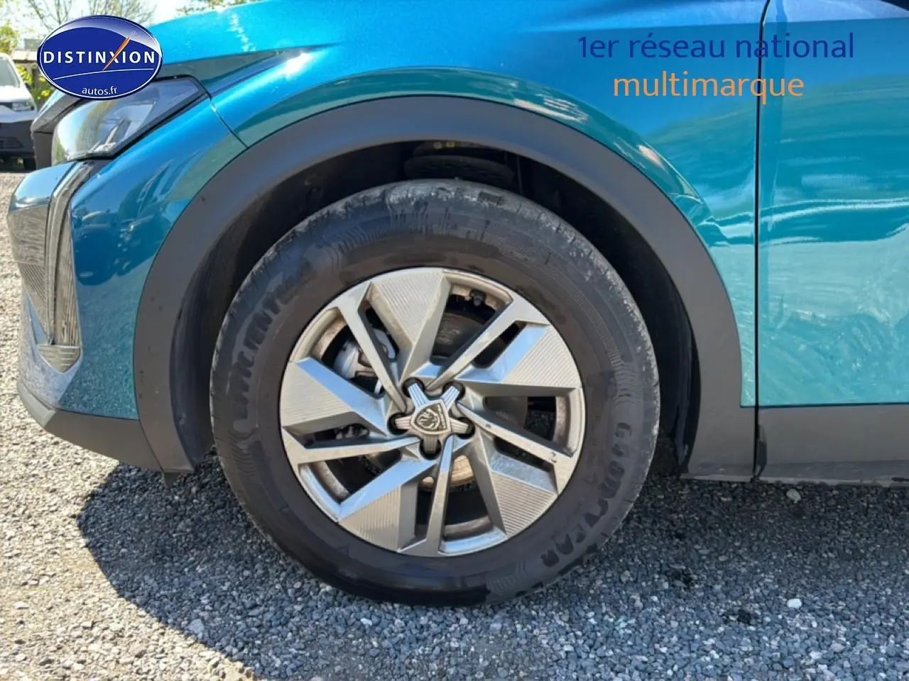Gros plan sur la roue avant gauche et la jante alu d’un Peugeot 408 Hybrid 145 allure bleu 2025.