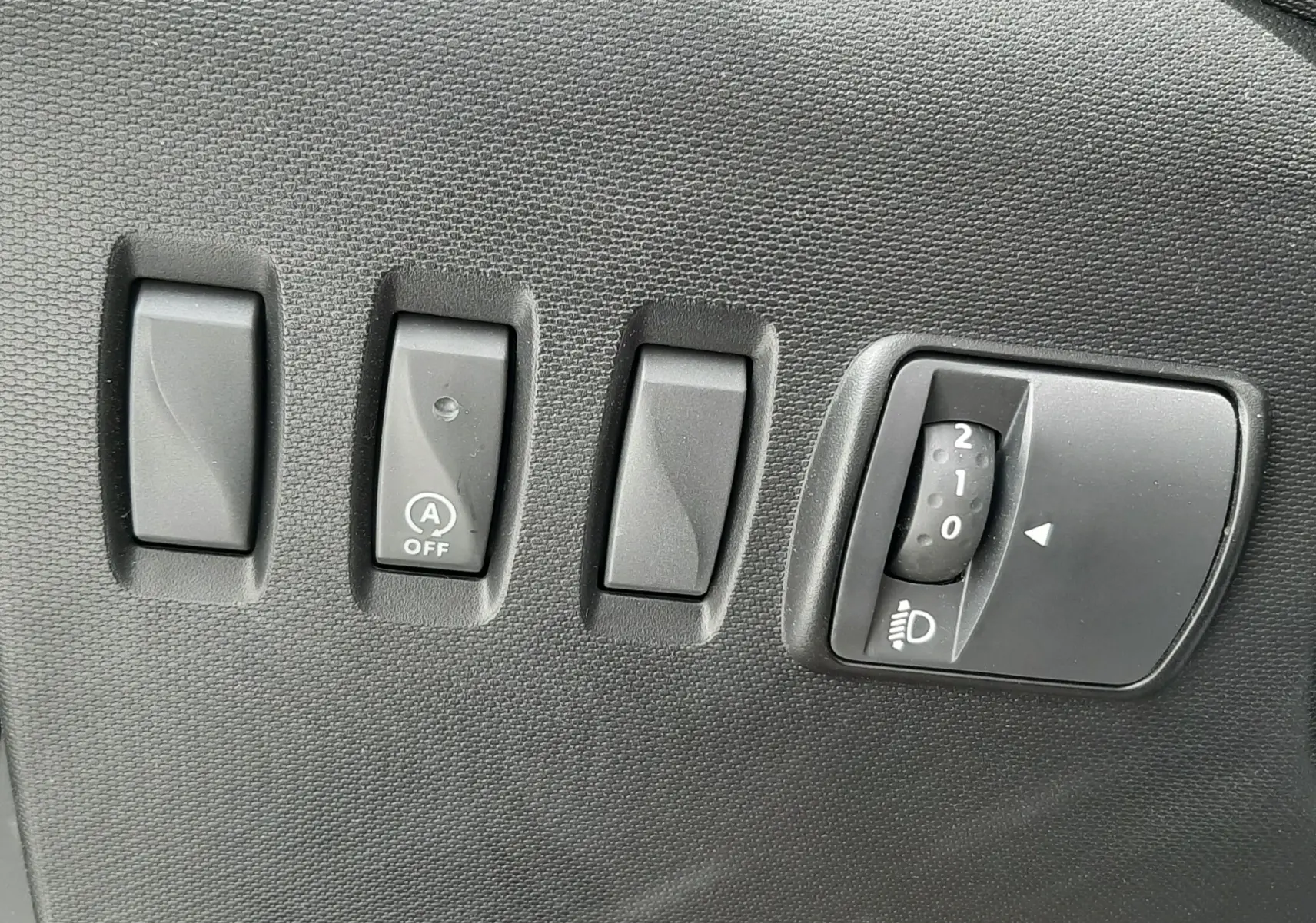 Vue plongeante sur la console centrale de la Renault Twingo III Life 2021, montrant frein à main et sièges tissu gris à motifs.