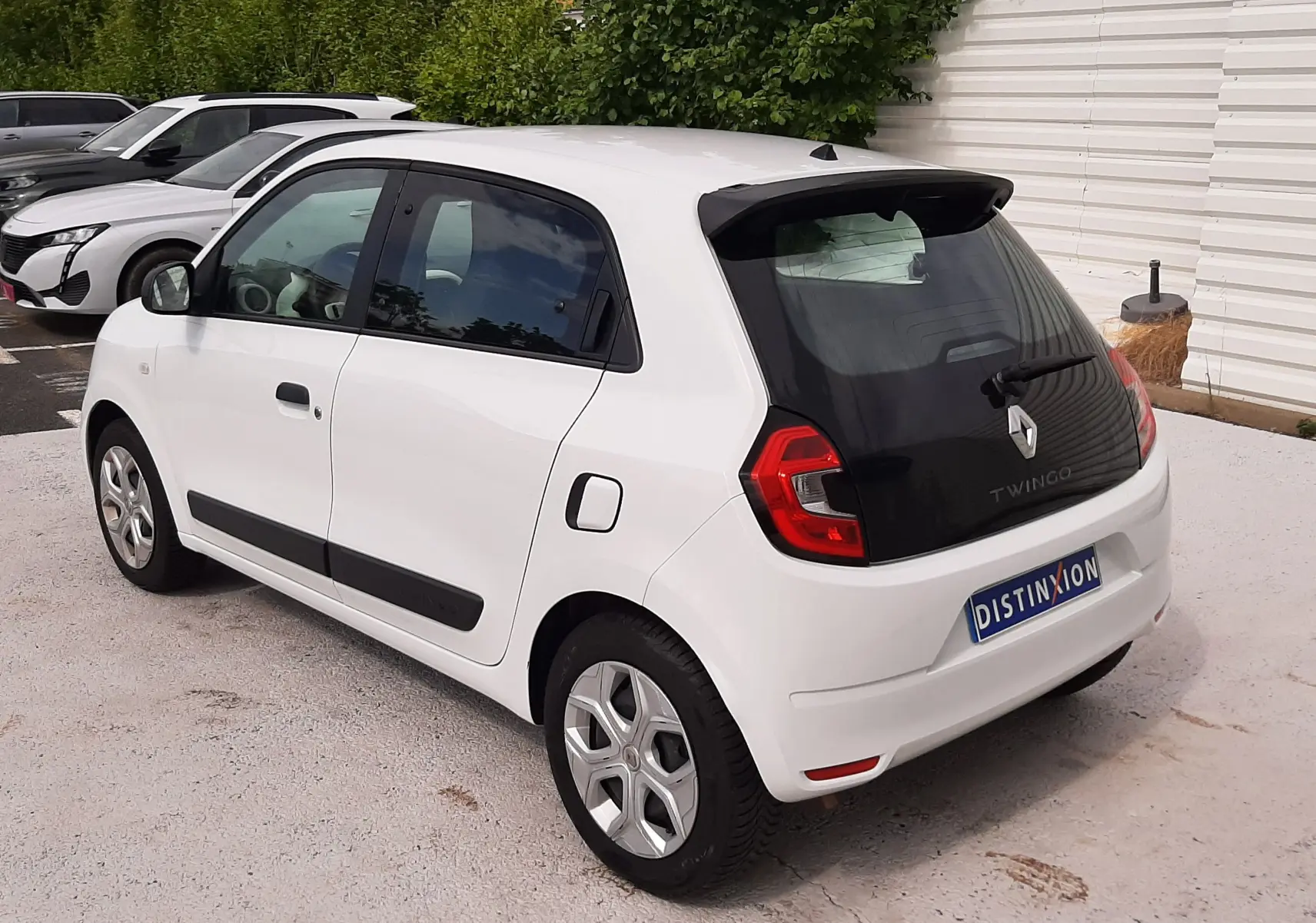 Renault Twingo III blanc cristal vue 3/4 arrière côté gauche, avec poignées noires et jantes originales.