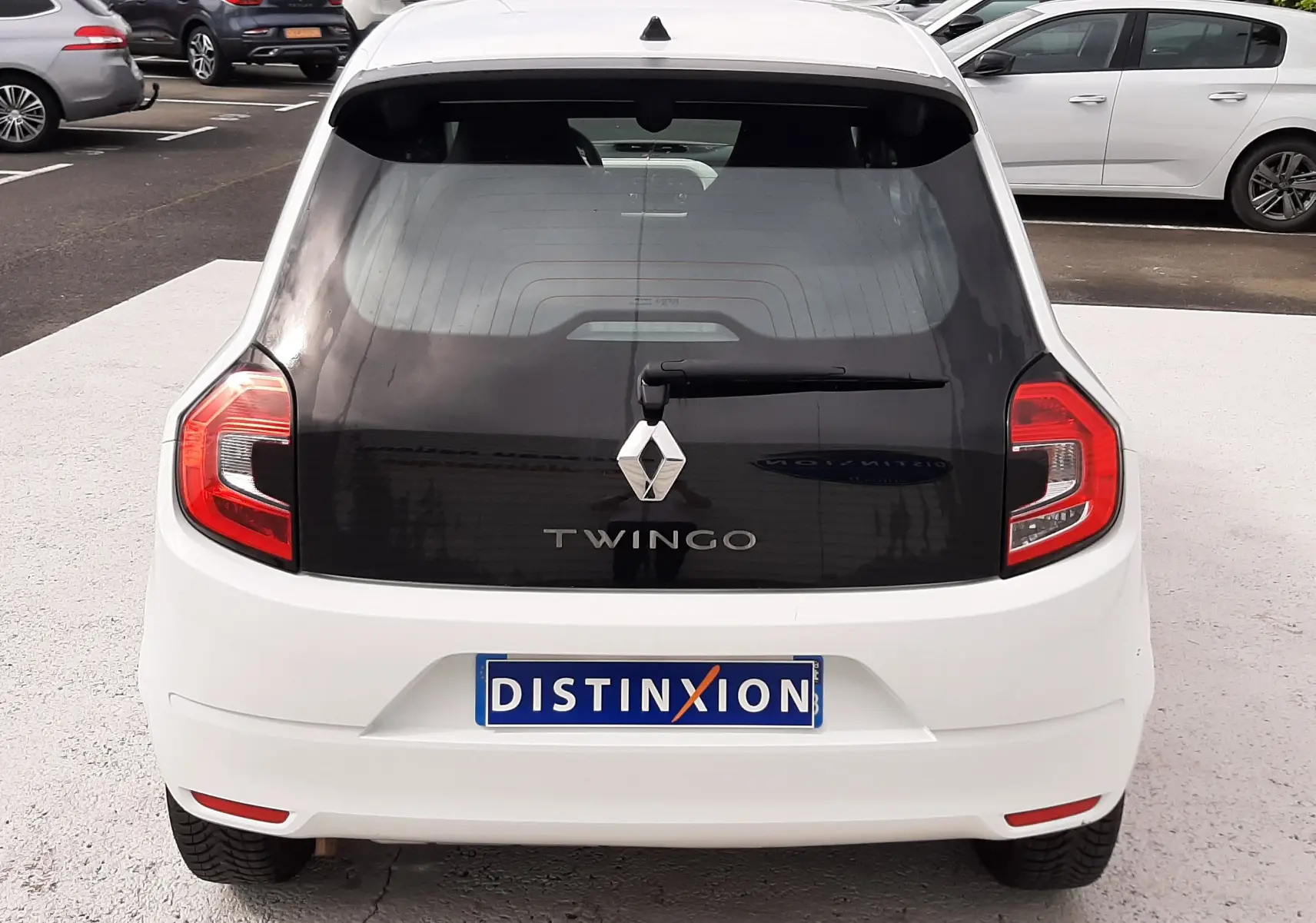 Vue 3/4 arrière droite d'une Renault Twingo III blanche cristal, avec vitres teintées et jantes alliage.