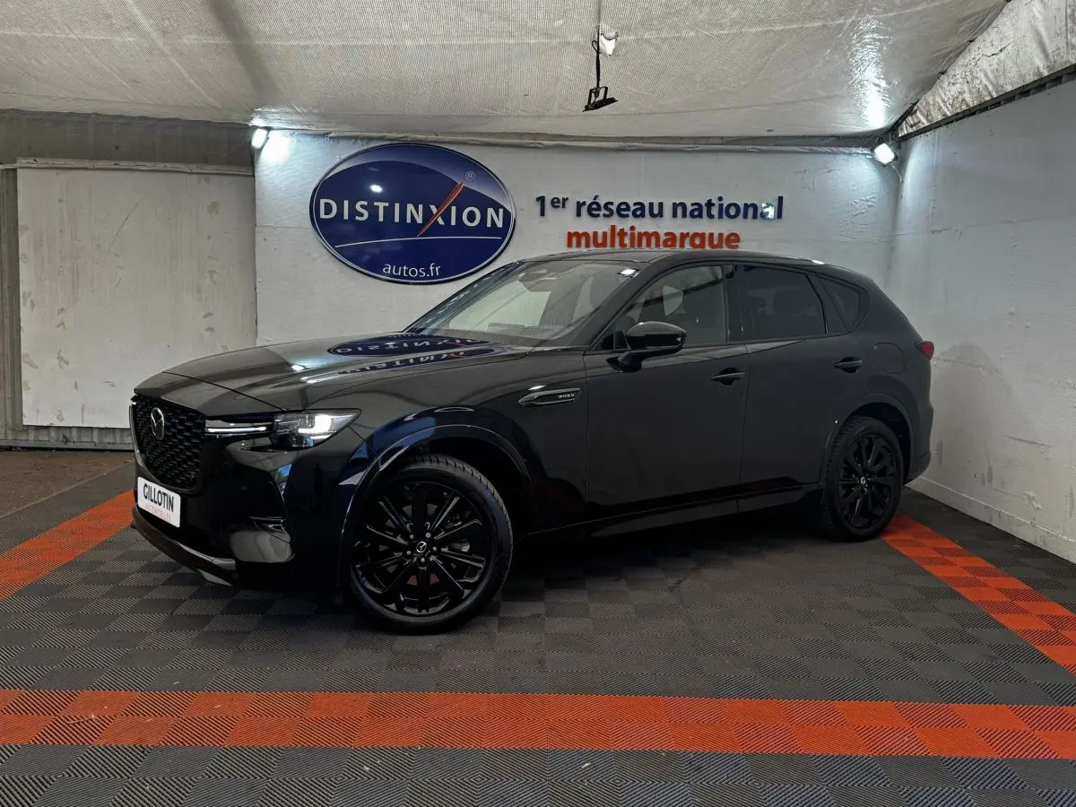 Vue 3/4 avant gauche du Mazda CX-60 noir 2024 avec jantes noires et calandre distinctive en intérieur showroom.