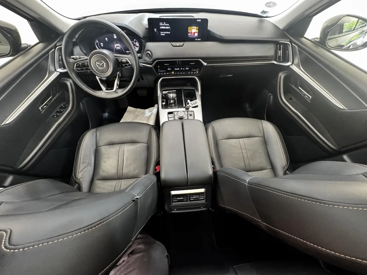 Vue intérieure avant du Mazda CX-60 noir 2024, avec tableau de bord moderne et écran tactile central.