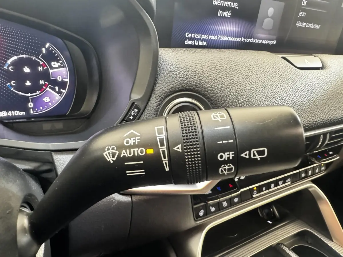 Gros plan sur la commande d’essuie-glace dans l’habitacle noir du Mazda CX-60 2024, tableau de bord et écran visibles.