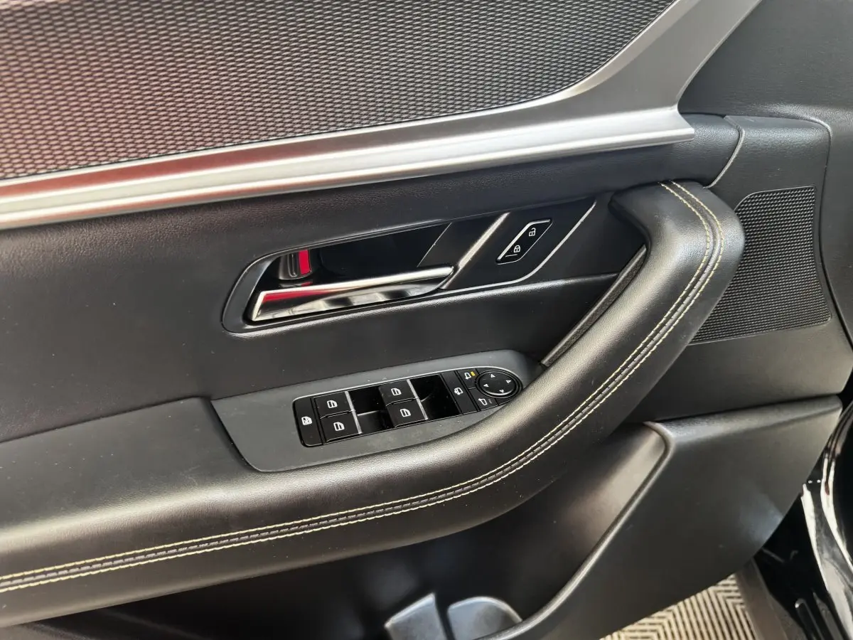 Gros plan sur la porte intérieure côté conducteur du Mazda CX-60 noir, avec commandes de vitres et verrouillage.