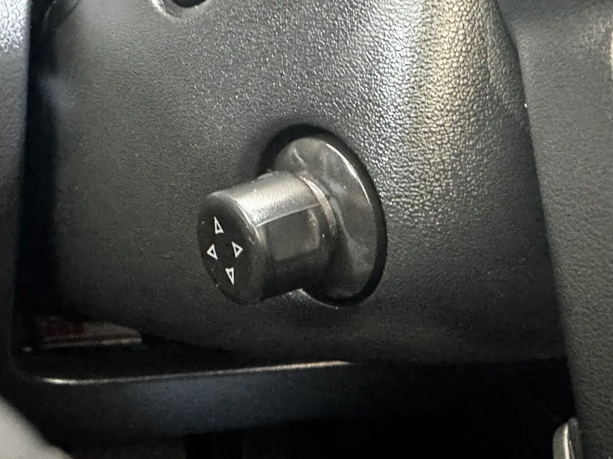 Gros plan sur la commande de réglage des rétroviseurs du Mazda CX-60 noir, détail intérieur côté conducteur.