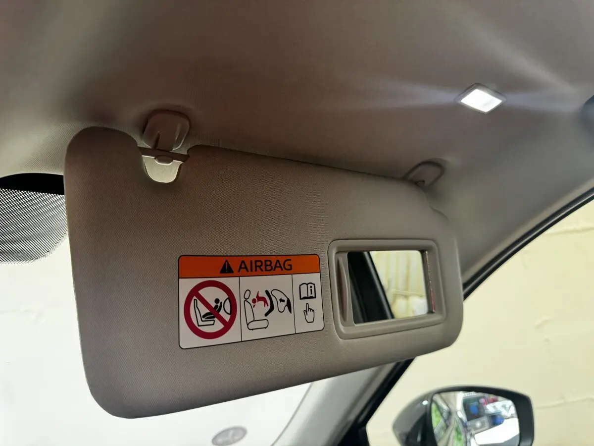 Détail du pare-soleil côté conducteur avec miroir et avertissement airbag dans un Mazda CX-60 noir 2024.