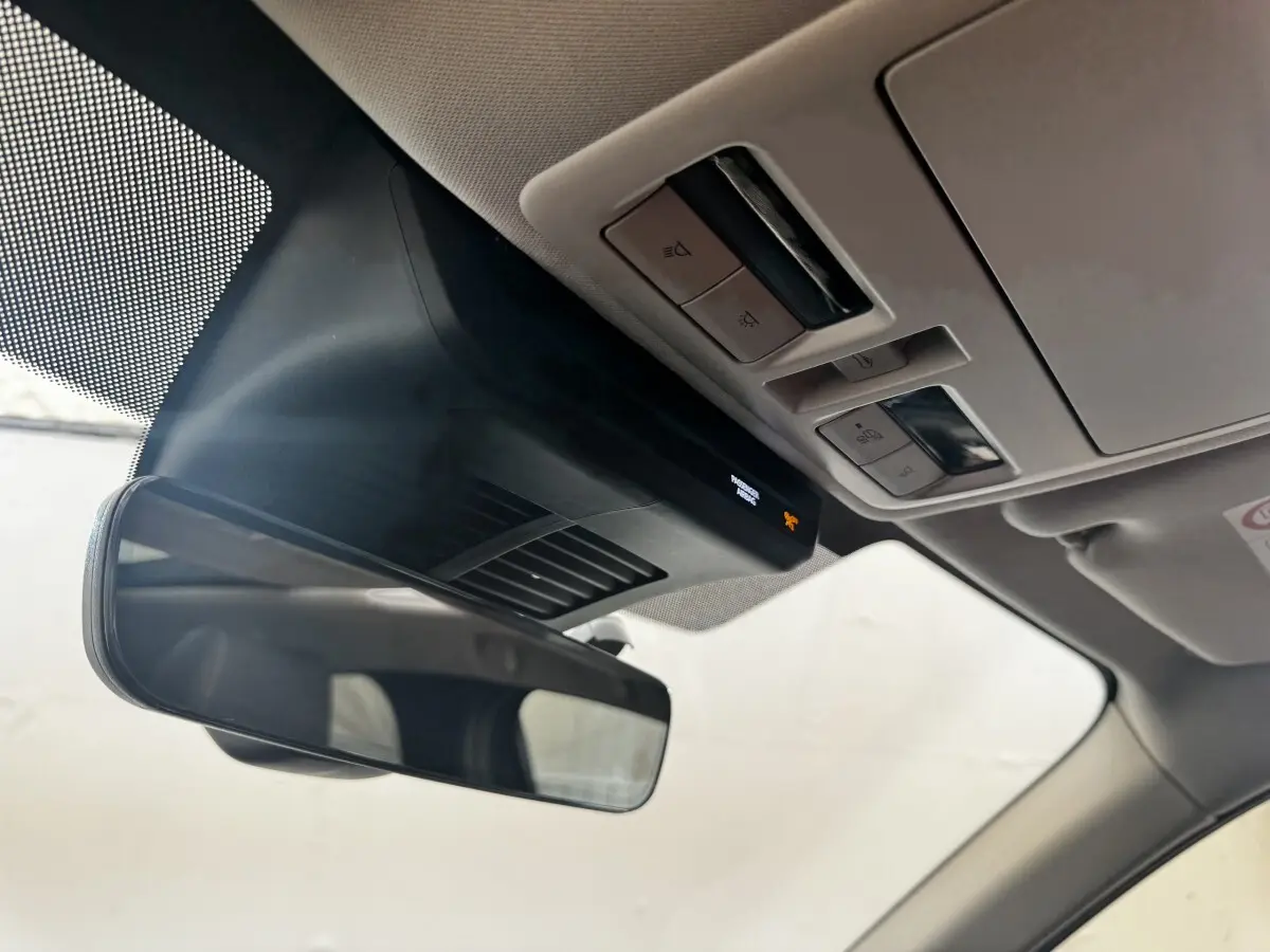 Vue intérieure rapprochée du rétroviseur et du plafonnier avec commandes lumineuses dans un Mazda CX-60 noir 2024.