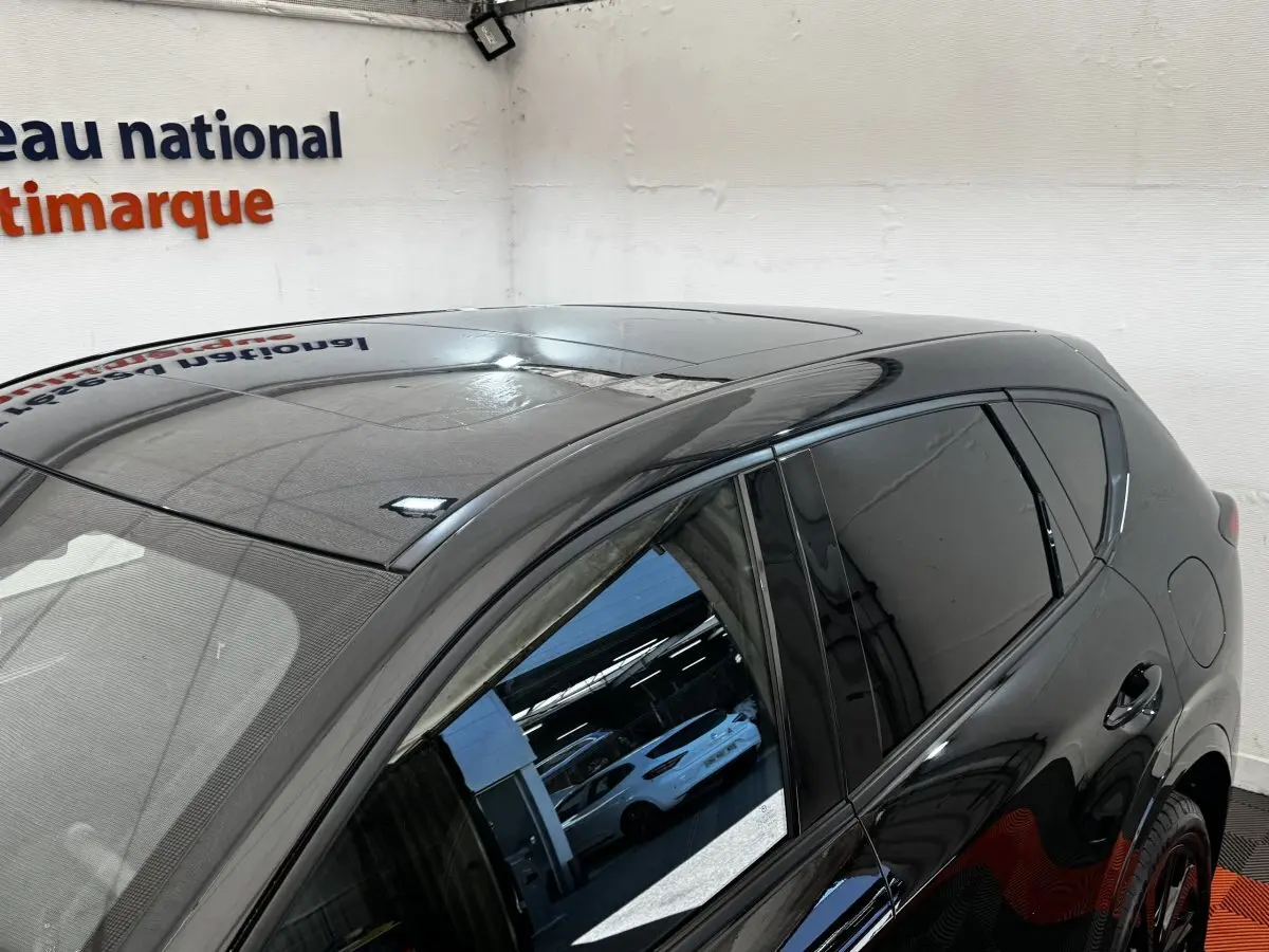 Vue partielle côté droit arrière du Mazda CX-60 noir 2024 avec toit panoramique et vitres teintées.