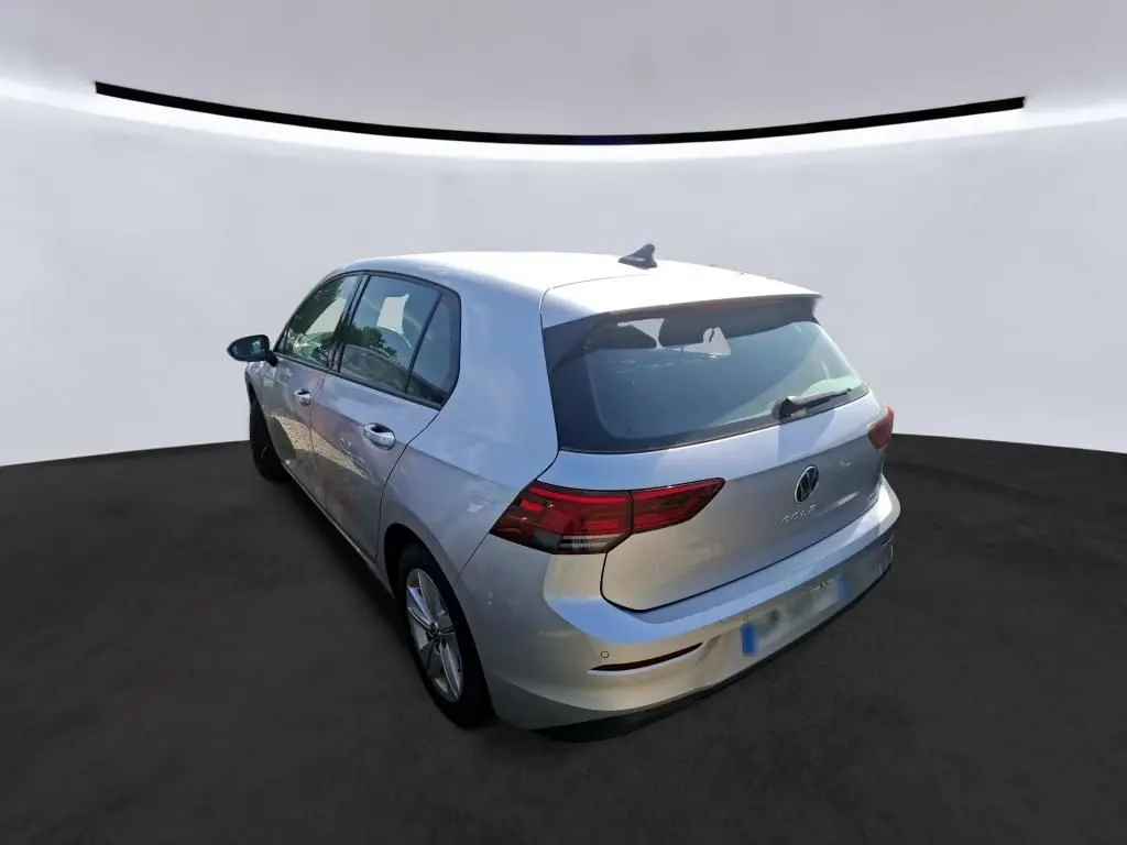 Volkswagen Golf gris clair vue 3/4 arrière droit, mettant en valeur les feux arrière et la silhouette compacte.