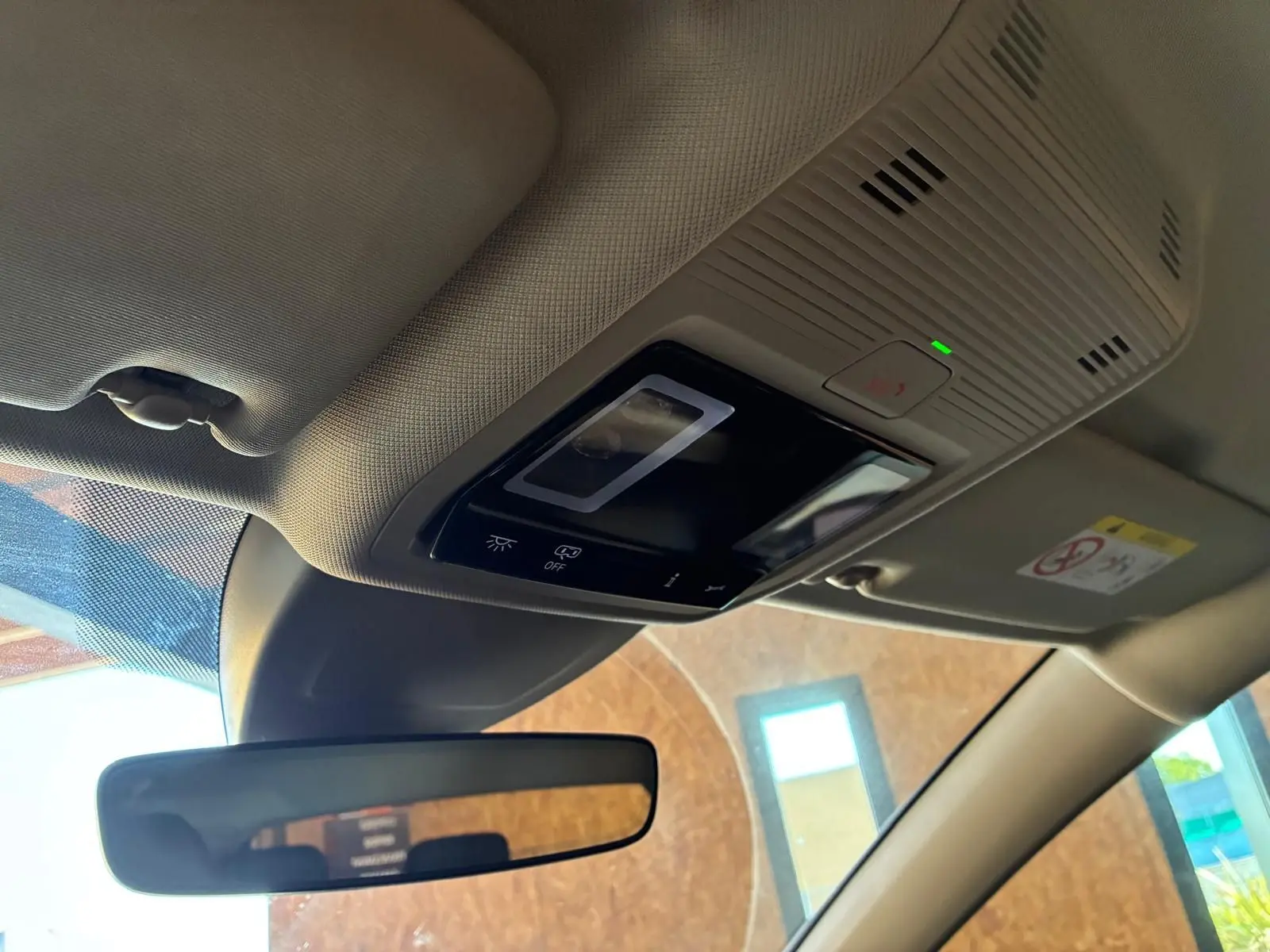 Détail du plafonnier beige avec commandes tactiles et rétroviseur intérieur d’une Volkswagen Golf gris clair 2023.