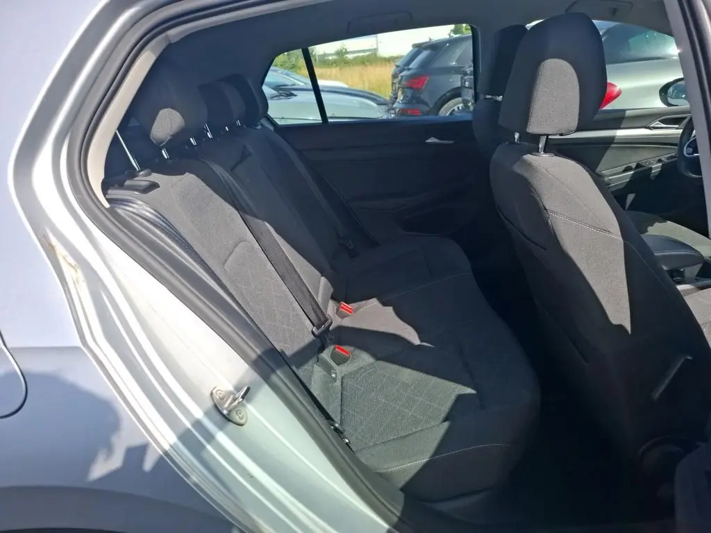 Vue intérieure côté gauche montrant les sièges arrière en tissu noir d'une Volkswagen Golf gris clair 2023.