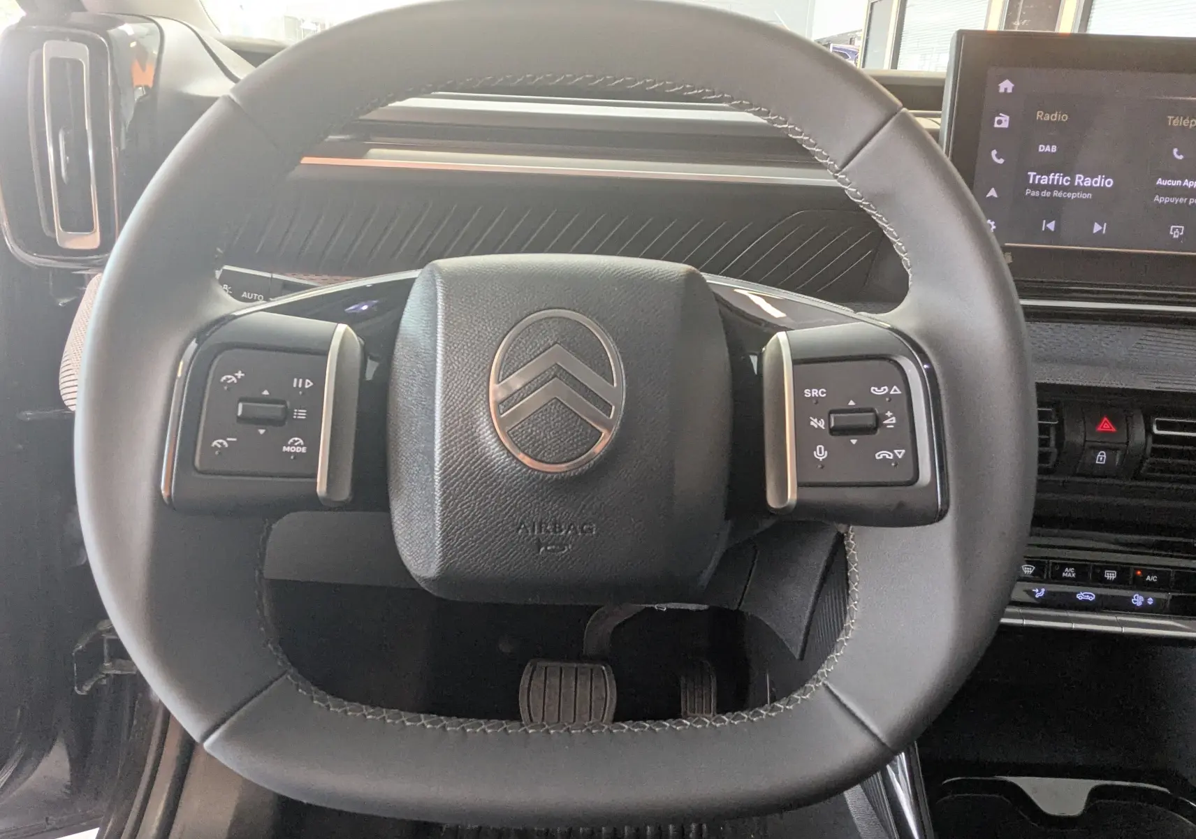 Vue rapprochée du volant noir de la Citroën E-C3 113 MAX 2025 avec commandes intégrées et tableau de bord moderne.