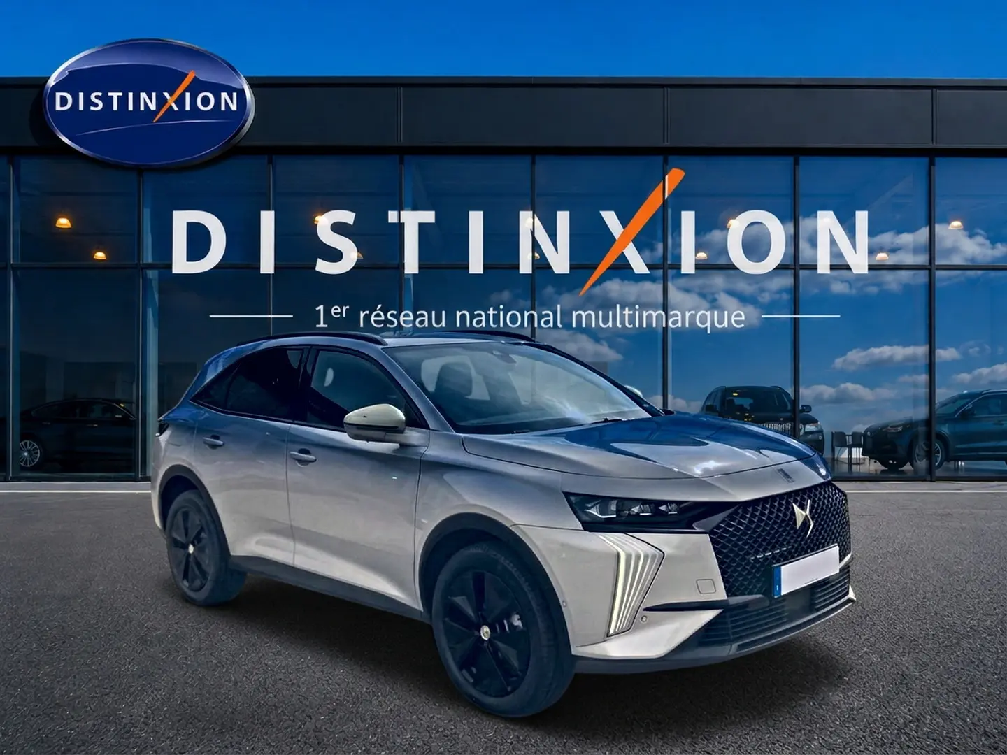 DS7 1.5 BlueHDi 130 Crystal Pearl en 3/4 avant droit, avec calandre distinctive et jantes noires devant un showroom Distinxion.
