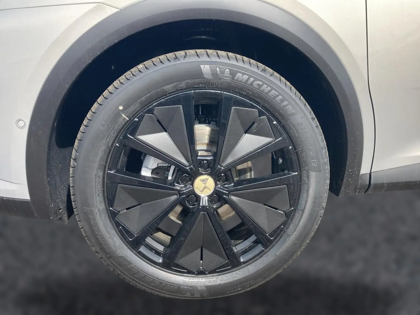 Gros plan sur la jante noire au design géométrique du DS7 Crystal Pearl, avec pneu Michelin visible.