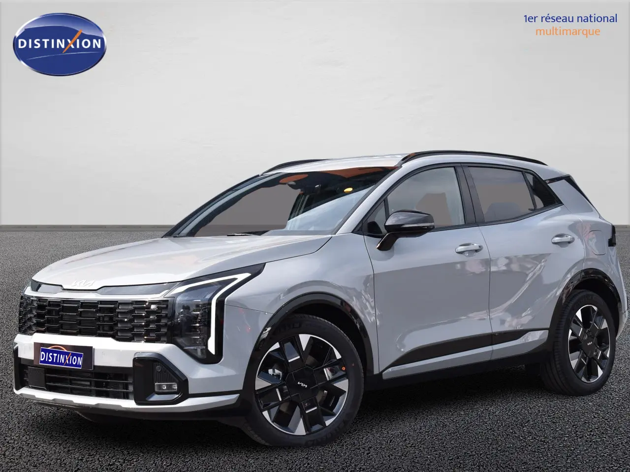 KIA Sportage hybride gris en 3/4 avant droit, avec calandre noire et jantes 19 pouces distinctives.