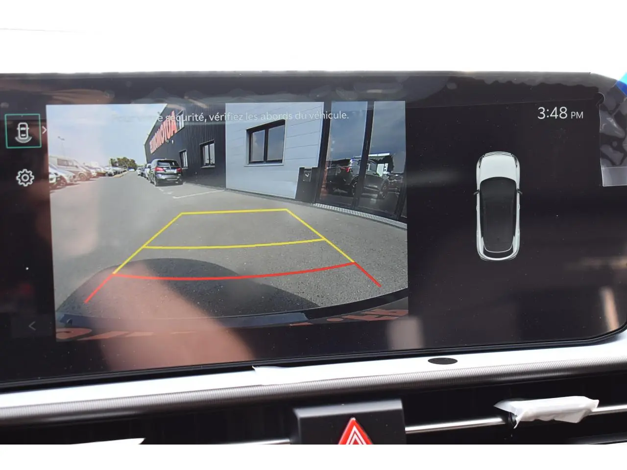 Affichage caméra de recul et vue 360° du Kia Sportage gris hybride 2026 sur écran tactile intérieur.