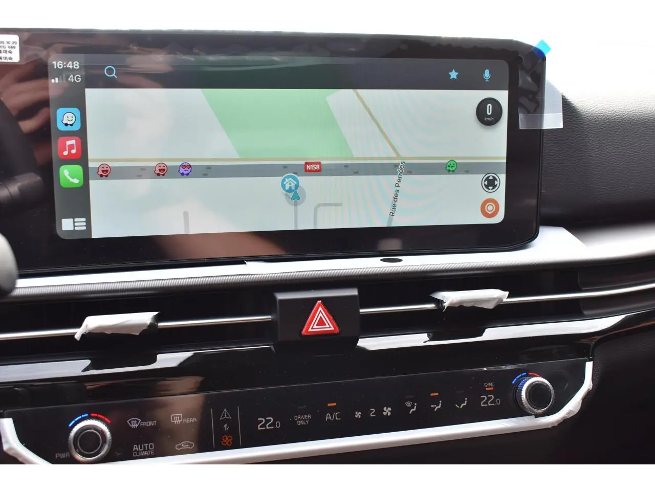 Vue rapprochée de l’écran tactile 12,3 pouces et de la console centrale du Kia Sportage gris, affichant la navigation.