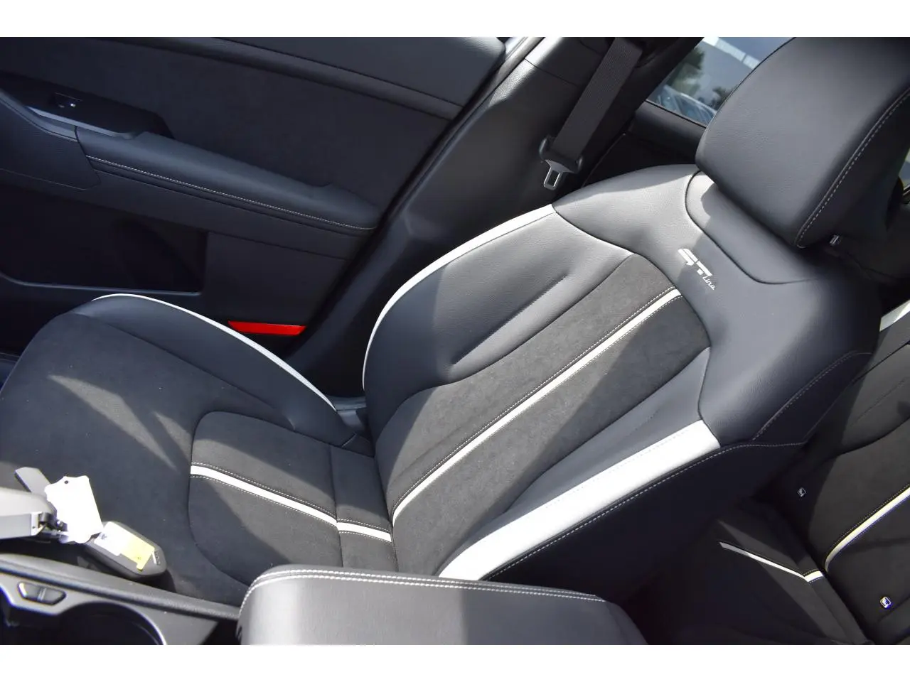 Gros plan sur le siège avant droit bi-ton noir et gris avec logo GT-Line du Kia Sportage hybride 2026.