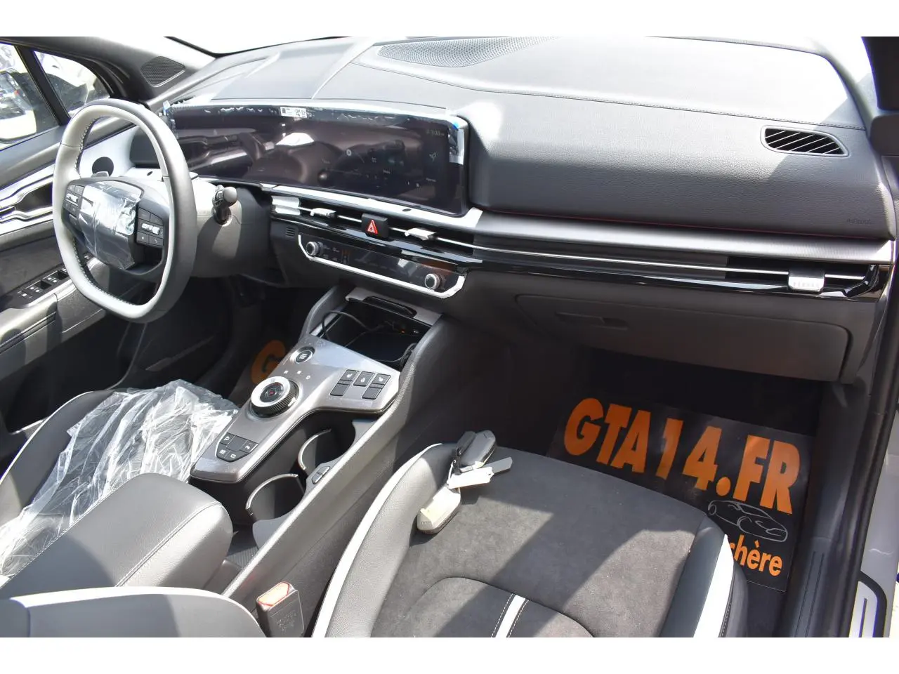 Vue intérieure côté passager du Kia Sportage gris 2026, mettant en valeur le tableau de bord digital et la console centrale moderne.