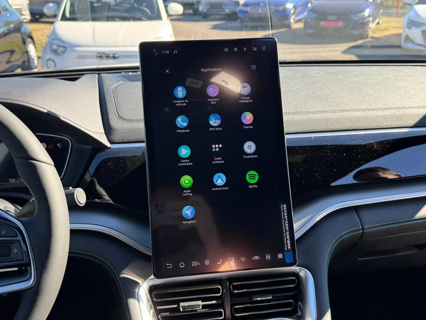 Vue intérieure centrée sur l'écran tactile vertical du tableau de bord du BYD SEAL U noir, volant partiellement visible à gauche.