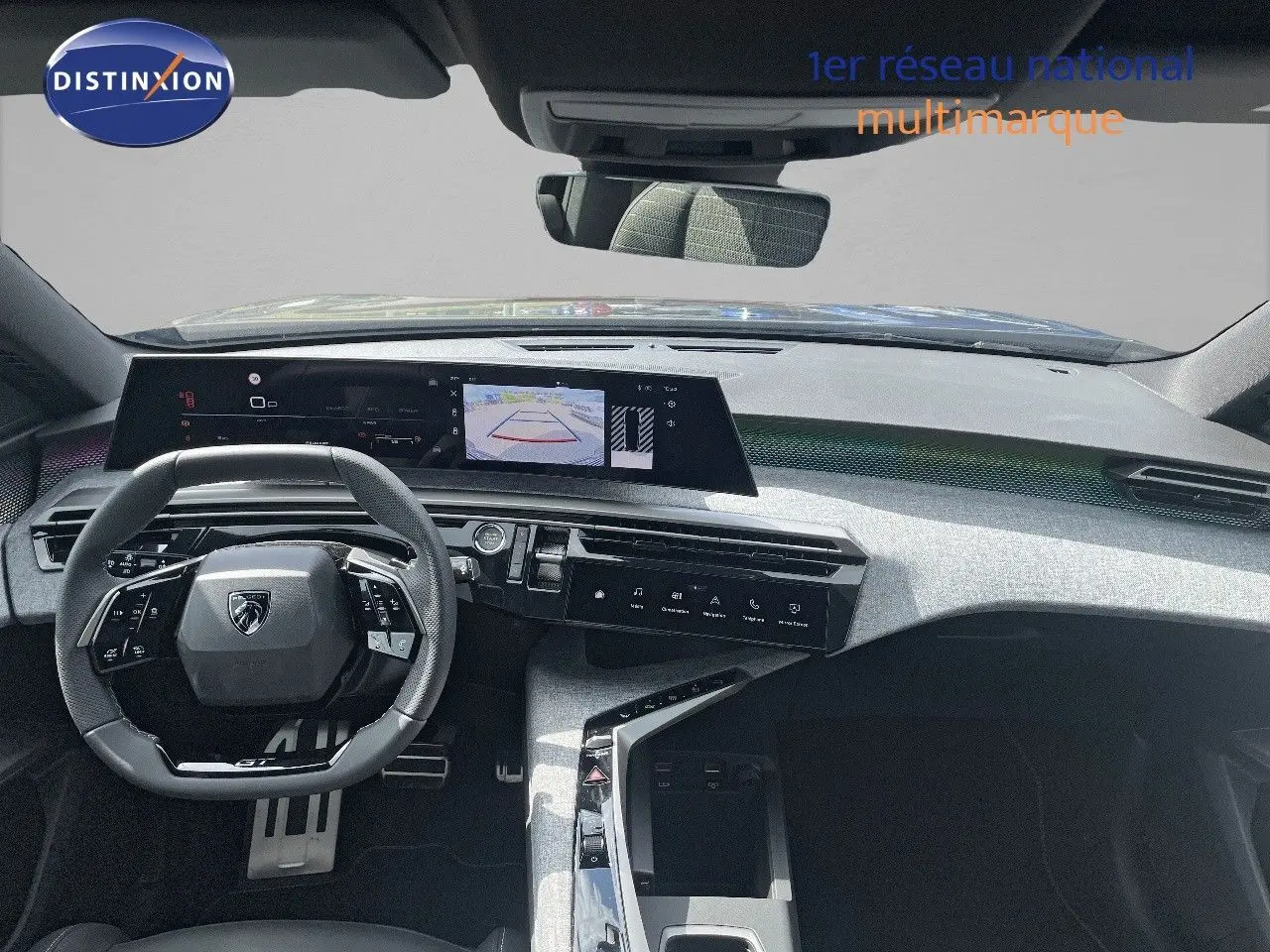 Vue intérieure du tableau de bord et volant noir du Peugeot 5008 Hybrid 136ch GT 2025 avec écran central tactile et caméra de recul affichée.