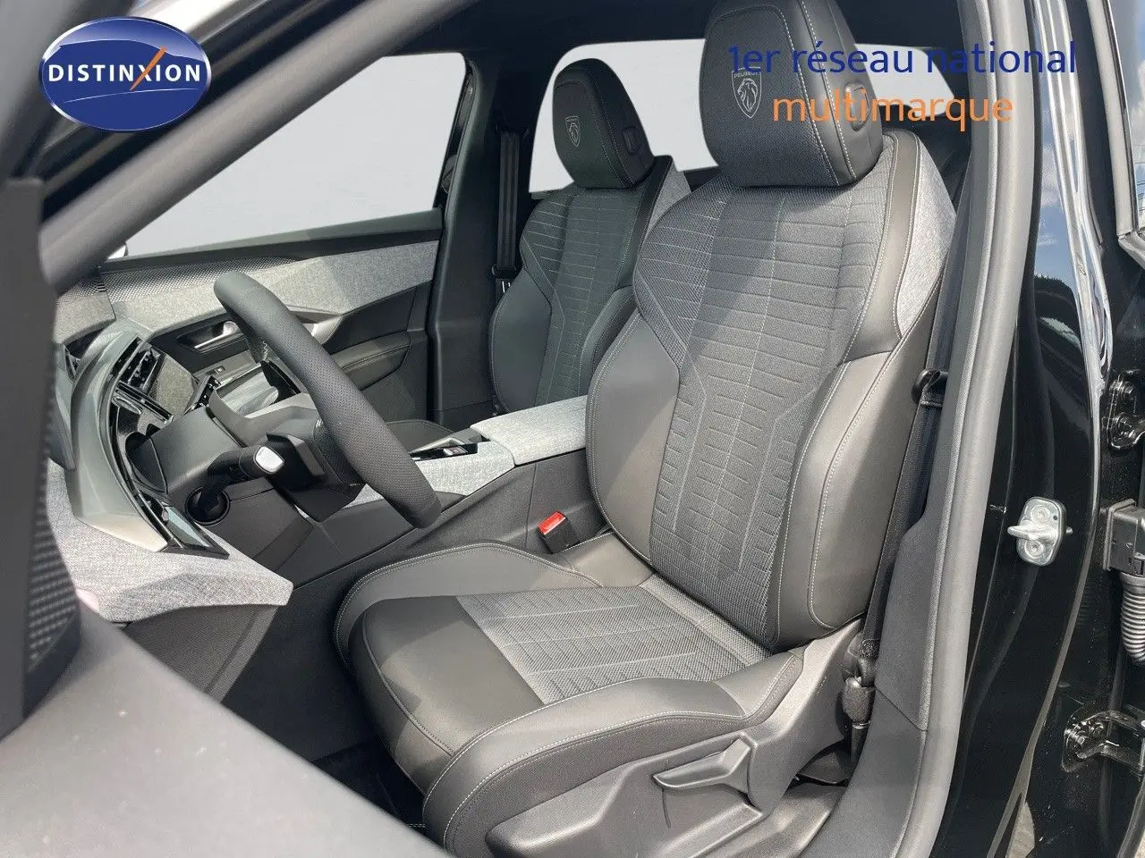 Intérieur du Peugeot 5008 Hybrid 2025 montrant les sièges avant en cuir noir et tissu gris, porte ouverte côté conducteur.