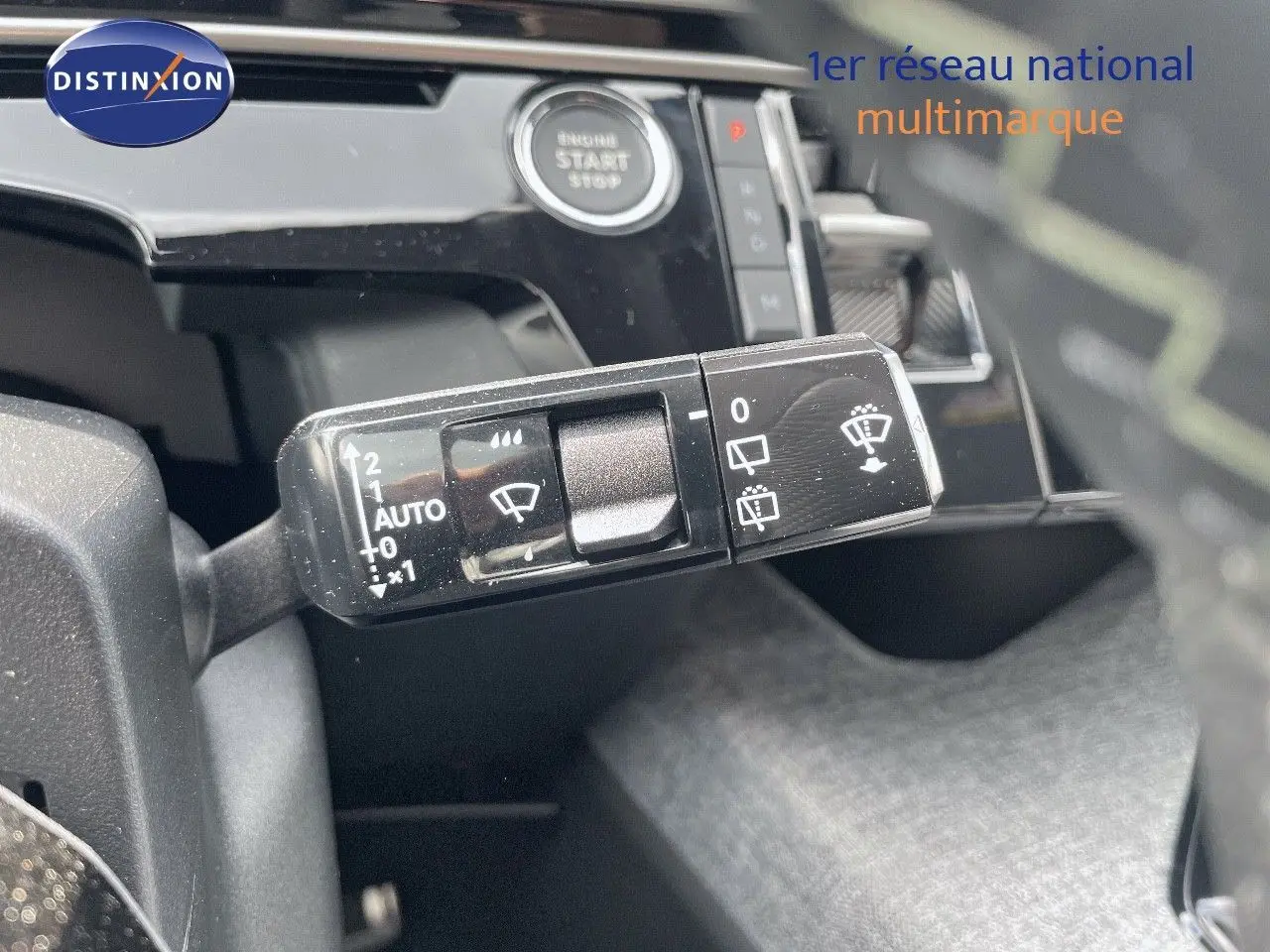 Gros plan sur la commande d'essuie-glace du Peugeot 5008 noir perle métal, avec bouton start visible en arrière-plan.