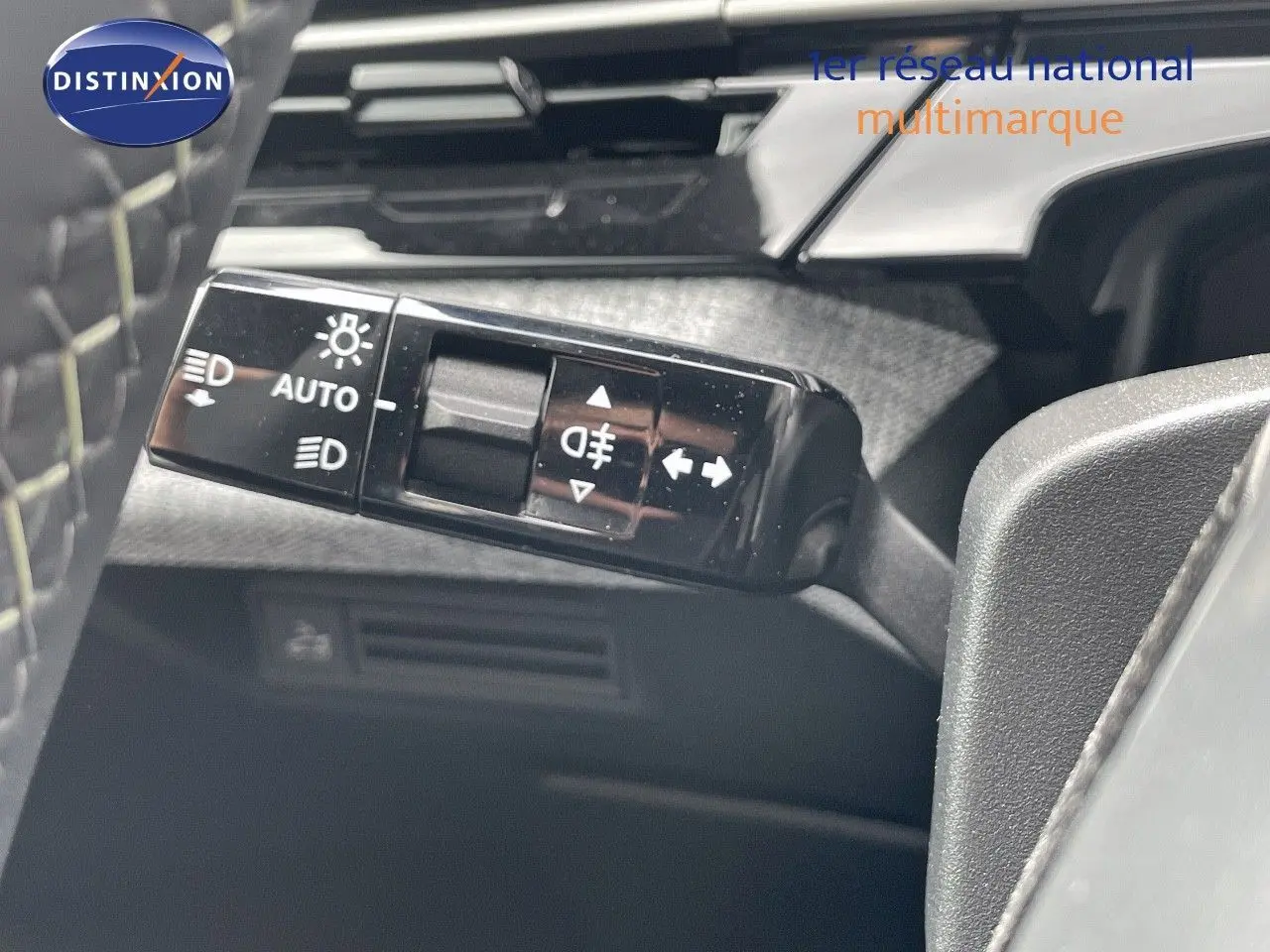 Gros plan sur la commande des feux automatiques et clignotants du Peugeot 5008 noir perle métal, version hybride 2025.