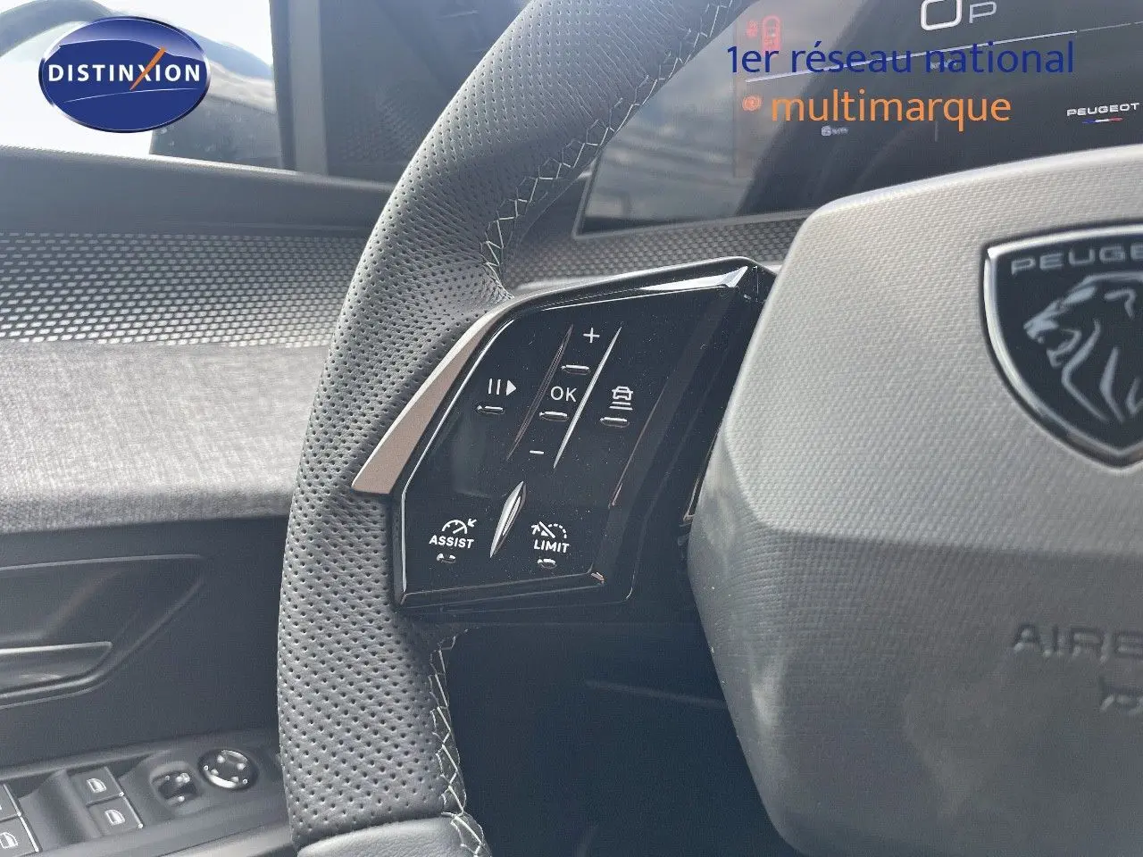 Gros plan sur le volant en cuir perforé avec commandes intégrées du Peugeot 5008 Hybrid 2025, intérieur noir et gris.
