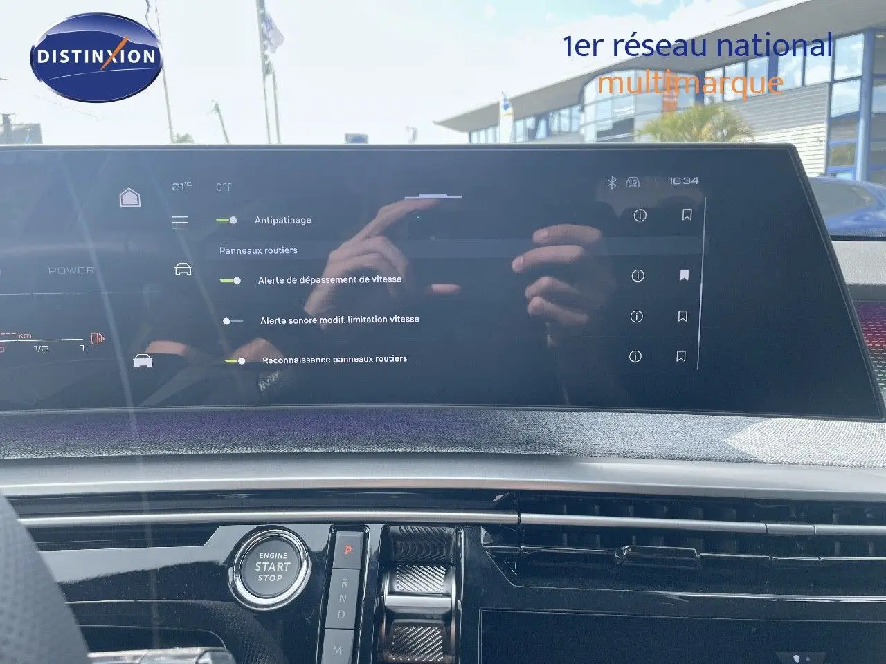 Vue intérieure du tableau de bord du Peugeot 5008 Hybrid 2025 avec écran tactile et bouton start/stop visible.