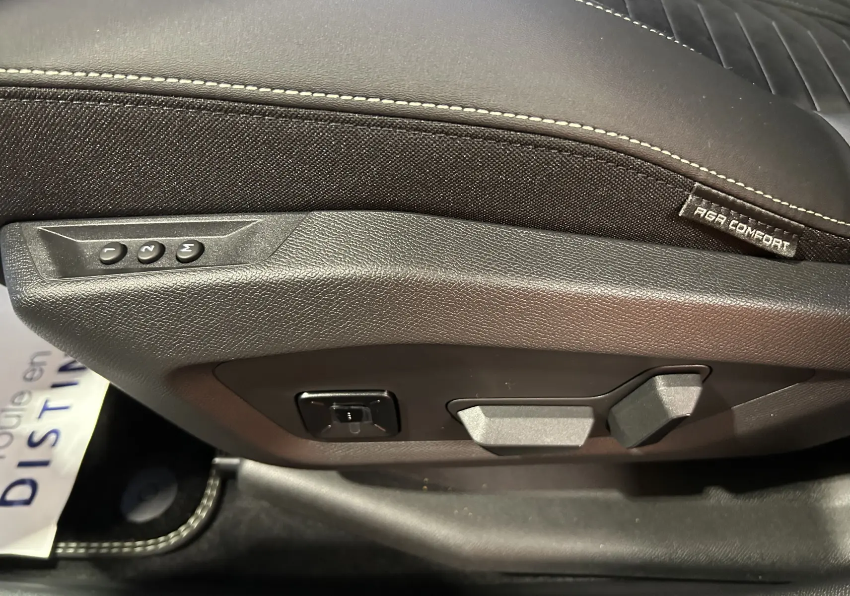Gros plan sur les commandes de réglage électrique du siège conducteur en cuir Alcantara noir sur Peugeot 3008 gris Artense.