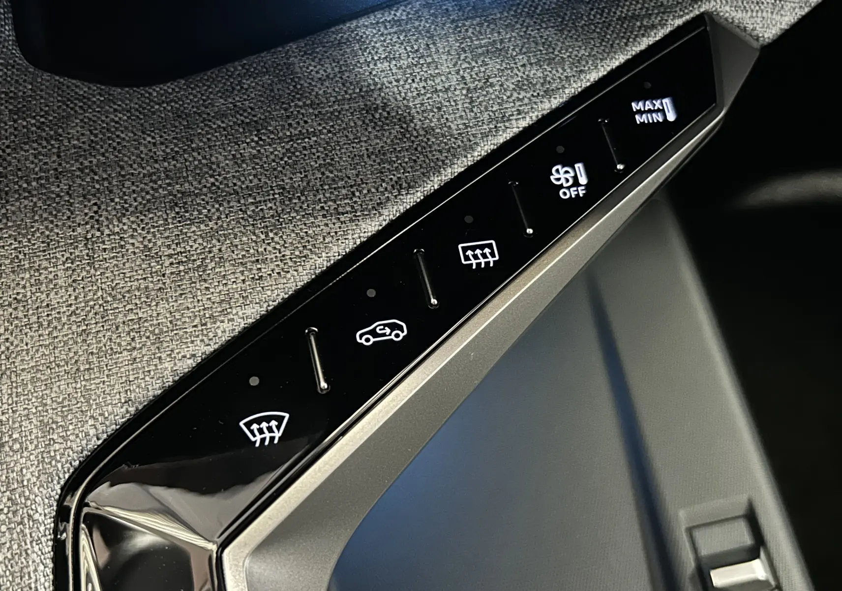 Gros plan sur la console centrale du Peugeot 3008 gris Artense, avec commandes tactiles éclairées de climatisation.