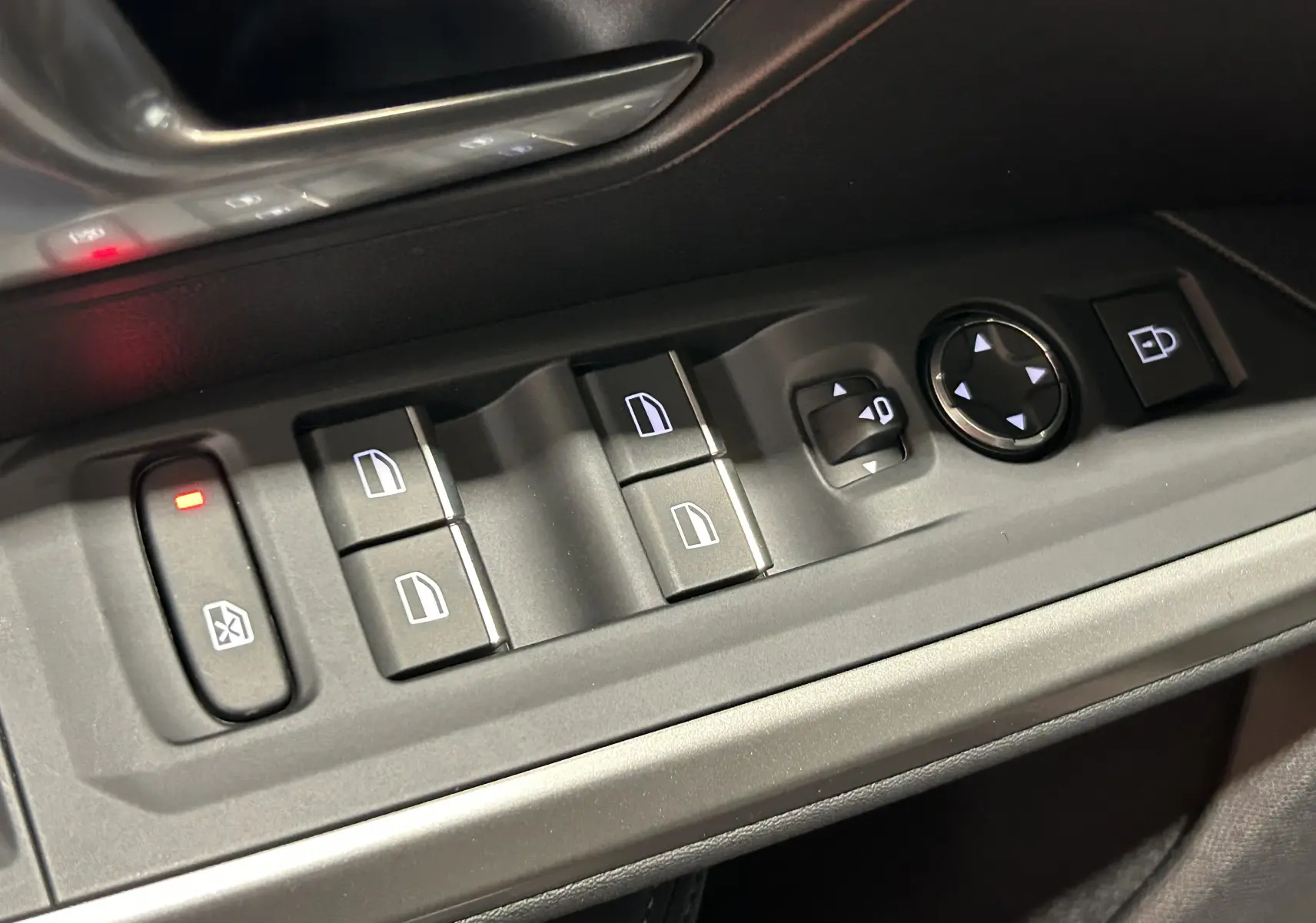 Gros plan sur les commandes de lève-vitres et rétroviseurs sur la porte conducteur d'un Peugeot 3008 gris Artense.