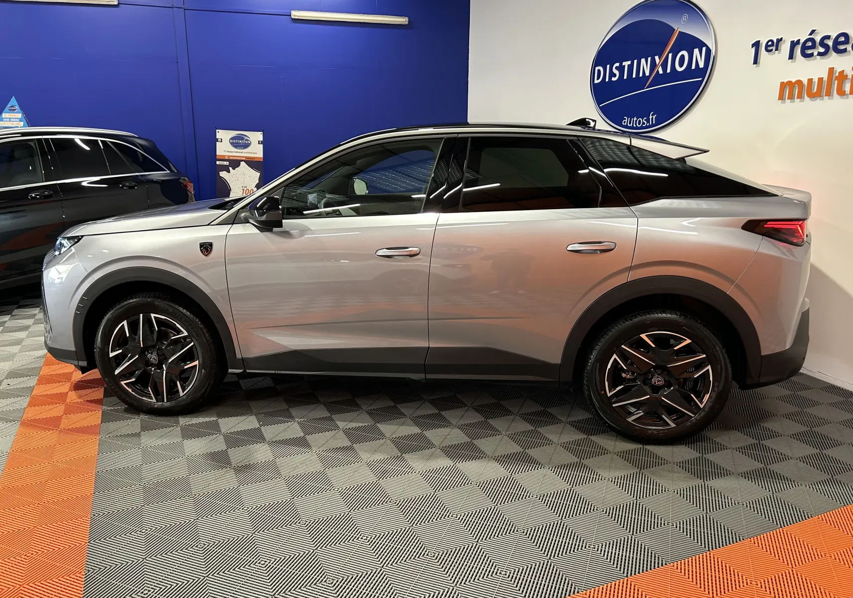 Vue de profil côté gauche du Peugeot 3008 III Hybrid gris Artense, soulignant ses jantes noires et détails noirs contrastants.